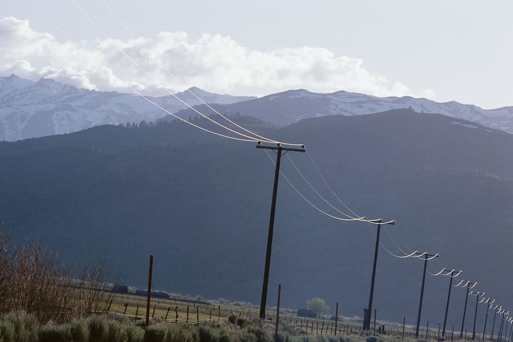 Telephone poles against mountain backdrop